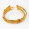 Detail of three-layer gold snake bone choker with ribbed texture and lobster clasp - Gold