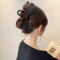 Detail of elegant black satin bow hair claw clip worn by a model for an upscale hairstyle - Black Bow (Glossy Clip 13cm)