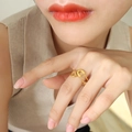 Verstellbarer Ring in Sicherheitsnadel-Form in Gold am Model mit unscharfem Grund - Sicherheitsnadel Ring (A126-Gold)