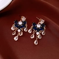 Macro shot of gold tassel earrings with blue pear-shaped stones on silk fabric - Silver Needle / Gold-Blue