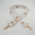 Detail view of beige canvas shoulder strap with blue daisy print and gold metal buckles - No. 12 White Orange Floral