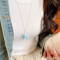 Close-up of light blue pony pendant necklace worn with a casual denim outfit - 20# Necklace Blue Light Blue Pony
