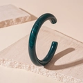 Macro view of dark green acrylic resin open bangle with imitation jade marble texture - Blue