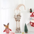 Detail of Christmas gnome with ho ho ho banner and retractable striped legs for home decor - Medium Santa / 18x40-68cm