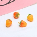 Dettaglio macro di quattro ciondoli a fragola in resina dai colori vivaci arancio e giallo - 6# Fragola Gialla Piccola 1pz