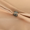 Close-up of silver magnetic hijab clip holding beige silk fabric with elegant metal finish - Silver Gray