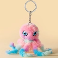 Porte-clés poulpe en peluche dégradé rose bleu et vert avec grands yeux sur fond beige - Multicolore