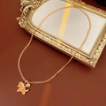 Nahaufnahme von goldenem Einhorn-Anhänger mit Glitzer und floralem Glücksbringer an Kette - Halskette - Gold