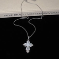 Detailed macro view of silver cross pendant with sparkling zircon inlays on dark background - Silver Zirconia Style