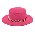 Détail d'un chapeau de paille rose fuchsia orné d'une grosse chaîne en acrylique doré - Rose rouge