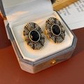 Detailansicht der Vintage-Ohrringe in Gold mit schwarzem Stein und Strasssteinen - Schwarz-Gold