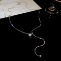 Detail of silver snake chain necklace with Y-shaped tassel and sparkling round zircon pendant - Ball Zirconia Style / Silver