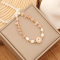 Detail of pink and white beaded bracelet with golden evil eye charm on jewelry box - 5# Rose Quartz