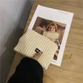 Fascia sportiva in maglia crema minimalista con etichetta a lettere nere su scrivania - Beige