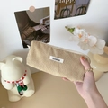 Detailed texture of beige corduroy pencil case with woven label held by hand - Apricot