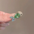 Gold fish brooch featuring a green pear-shaped stone and blue crystal tail fins - Phantom Goldfish