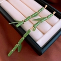 Detailed view of bamboo-shaped long earrings with green leaves in a black jewelry box - Asymmetrical Style / Green Bamboo Joint Leaf (Silver Pin)