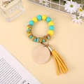Detail of colorful silicone bead keychain with a blank wooden tag and stylish leather tassel - Yellow Blue Green Colorful Beaded