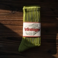 Chaussettes en coton côtelé vert vintage avec emballage papier sur fond de bois sombre - Taille Unique / Avocat