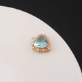 Macro shot of gold-plated heart pendant with light blue zircon and clear crystals detail - Aqua