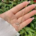 Primer plano del collar de lazo bañado en oro 18K con circonitas y cuentas de metal - Blanco