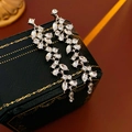 Dettaglio orecchini a foglia d'argento con cristalli su portagioie verde scuro - Orecchini Pendenti con Frange a Foglia in Zirconia Argento