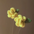 Dettaglio macro di orecchini a fiore in velluto giallo con foglia verde e consistenza - Giallo
