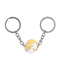 Close-up of interlocking black and gold cat pendants in yin-yang style on keychains - Round Gold Silver Cat