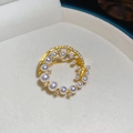 Macro de un broche de flor en oro de 18k con circonitas y perlas en un estuche de terciopelo - Círculo Dorado (Bañado en Oro Real)