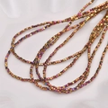 Macro shot of 2mm rainbow hematite cube beads with metallic shimmer for jewelry making - Rose Red Gold