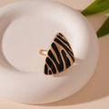 Detail eines Dreieck-Rings mit schwarz-goldem Zebra-Muster auf mattem Tablett - Schwarzer Ring mit Leopardenmuster, verstellbar, Dreieck