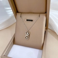 Dettaglio della collana con ciondolo portafortuna in un astuccio beige su seta - Argento