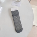 Schicke graue Wadenstrümpfe mit Rippmuster flach auf weißem Tisch mit Dekoration - Verpackte Schlanke Streifen / Dunkelgrau