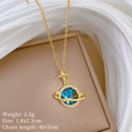 Macro shot of gold planet pendant with blue stone and star details on beige stand - Blue Planet Style (F145)