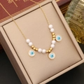 Collier élégant en or avec perles blanches et breloques œil bleu dans un coffret - Style Mauvais Œil