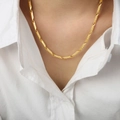 Elegant gold-tone geometric Greca pattern link necklace worn on a white shirt - Engraved Version / Gold
