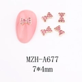 Detail of pink rhinestone bow nail art charm with gold alloy frame on a manicure model - A677