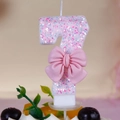 Detailed close-up of a pink number 7 birthday candle with glitters and a pink bow - Number 7