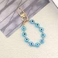 Detail of blue evil eye beads with gold accents on a stylish beaded keychain - Lake Blue