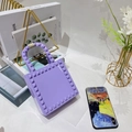 Dettaglio borsa jelly in PVC viola con borchie e manico unico su libro di moda - Violetto