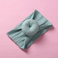 Detailed close-up of light teal nylon baby headband with knitted donut knot texture - Blue Gray