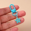 Detail of blue flower keychain charm with gold-rimmed petals and matching D-ring - Blue Flower