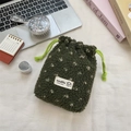 Close-up of green fleece drawstring storage bag with heart design on a desk setup - Green with White Polka Dots