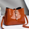 Close-up of caramel crocodile pattern tote bag with polished finish and gold metal buckle - Khaki/Earth Yellow