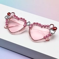 Dettaglio degli occhiali da sole a cuore con strass rosa e decorazioni in cristallo - Montatura Rosa Lente Rosa Sfumato