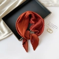 Detailed view of caramel pleated silk scarf artfully arranged on a sleek black tray - 70*70cm / Pleated Caramel