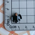 Detailed view of a small black resin ghost charm with orange eyes on a cm measuring mat - Black Ghost