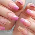 Uñas postizas degradadas en rosa con purpurina dorada mostradas de cerca en las manos - 24 Uñas + Pegamento de Gelatina