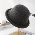 Detailed texture of thick dark grey wool cloche hat on a premium display stand - Gray