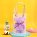 Detail of purple bear-shaped towel gift in a transparent bag with a decorative ribbon - Purple